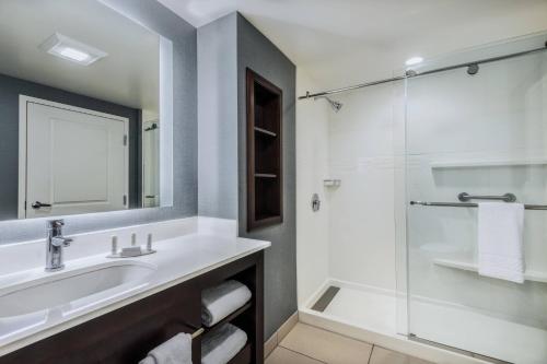夏洛特Residence Inn by Marriott Charlotte City Center的一间带水槽和玻璃淋浴的浴室