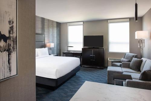 波士顿Residence Inn Boston Downtown/South End的酒店客房配有床、沙发和电视。