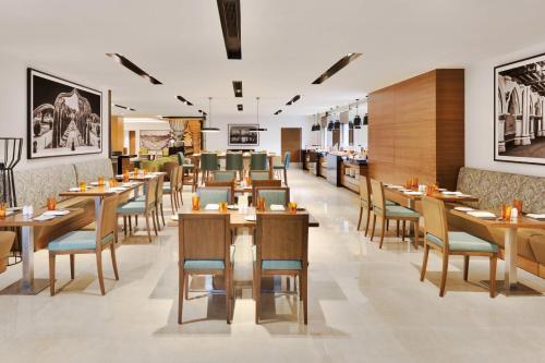 班加罗尔Fairfield by Marriott Bengaluru Whitefield的用餐室配有木桌和椅子