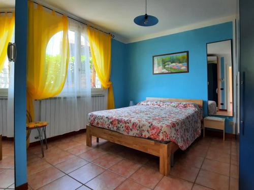 卡尼洛瑞维拉Appartamento Porto 1的一间卧室配有一张蓝色墙壁和黄色窗帘的床