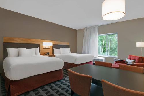 利马TownePlace Suites By Marriott Lima的酒店客房设有两张床和一张桌子。