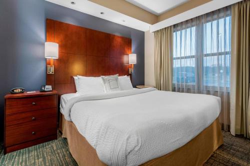 哥伦布哥伦布居家酒店的一间卧室设有一张大床和一个大窗户