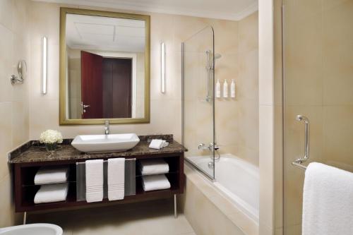 麦纳麦巴林玛纳玛万豪行政公寓的浴室配有水槽、淋浴和浴缸。