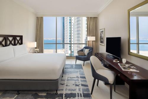 麦纳麦巴林玛纳玛万豪行政公寓的酒店客房带一张床铺、一张书桌和一间卧室