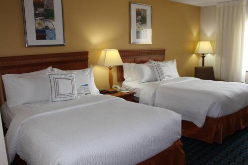 利伯蒂堪萨斯自由城菲尔德套房酒店的酒店客房,配有两张带白色床单的床