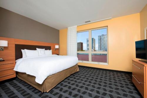 尚佩恩万豪香槟广场套房酒店的一间卧室设有一张大床和一个大窗户