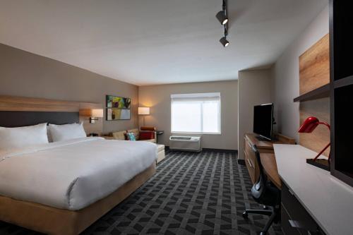圣安东尼奥TownePlace Suites San Antonio Northwest at The RIM的配有一张床和一台平面电视的酒店客房