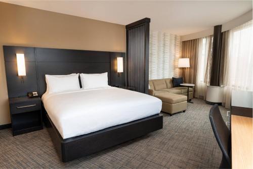 大急流城Residence Inn by Marriott Grand Rapids Downtown的酒店客房带一张大床和一把椅子