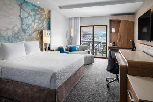 西班牙港西班牙万豪万怡酒店的酒店客房配有一张床、一张桌子和一把椅子。