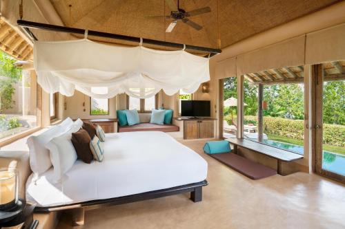 Ko NakaThe Naka Island, a Luxury Collection Resort & Spa, Phuket的一间带大床的卧室和一个游泳池