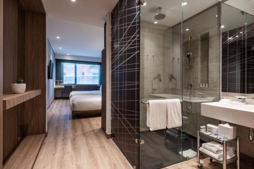 波哥大AC Hotel by Marriott Bogota Zona T的带淋浴和盥洗盆的浴室以及1张床。