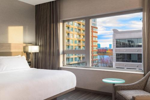 梅德福AC波士顿北万豪酒店的一间卧室设有一张床和一个大窗户