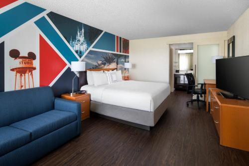 安纳海姆Fairfield by Marriott Anaheim Resort的酒店客房配有床、沙发和电视。