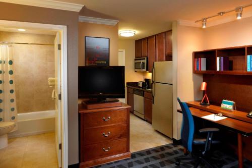 兀兰北休斯顿唐普雷斯套房/谢南多厄酒店的客房设有书桌、电视和厨房。