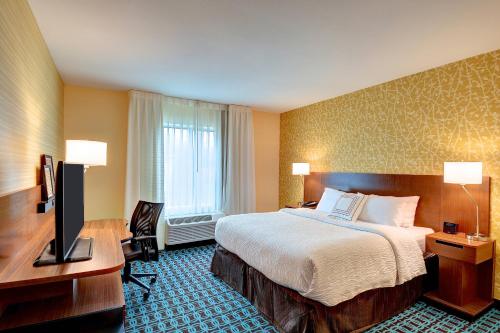 纳什维尔Fairfield Inn & Suites by Marriott Nashville Downtown-MetroCenter的酒店客房配有一张床、一张书桌和一台电视。