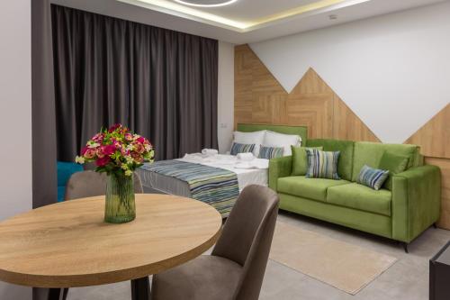 帕莫瑞Inter Holiday Apartments的客厅配有绿色沙发和桌子