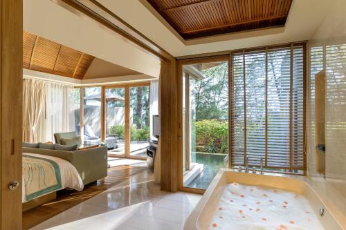 迈考海滩普吉万丽度假酒店的主卧室配有浴缸和床。