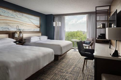 杰克逊维尔Marriott Jacksonville的酒店客房设有两张床和窗户。