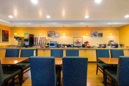 欧弗兰帕克堪萨斯城欧弗兰帕克万豪广场套房酒店的一间带桌椅的餐厅和一间酒吧