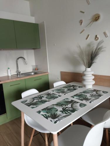 维什库夫Telimena的厨房配有白色桌子和绿色橱柜