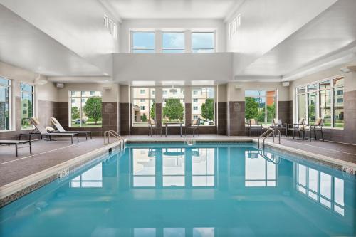 皮奥里亚Residence Inn by Marriott East Peoria的一座带窗户的建筑里,有一个蓝色的游泳池