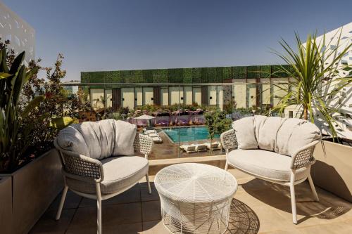 拉巴特Rabat Marriott Hotel的一个带两把椅子和一张桌子的庭院和一个游泳池