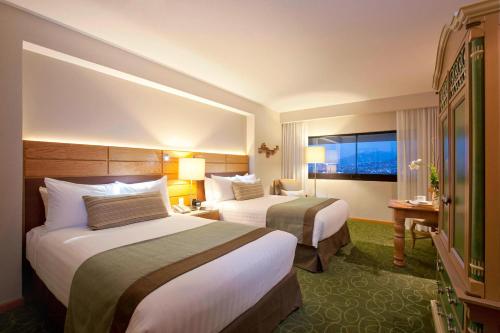 图斯特拉古铁雷斯万豪图斯特拉古铁雷斯酒店 的酒店客房设有两张床和窗户。