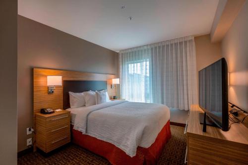 列克星敦TownePlace Suites by Marriott Lexington Keeneland/Airport的配有一张床和一台平面电视的酒店客房