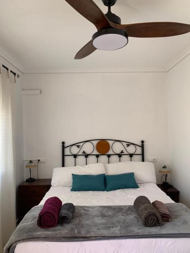 马力诺港Adosado tranquilo con piscina y vistas al mar的一间卧室配有一张带吊扇的床