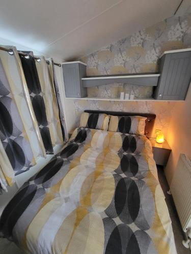 海斯廷斯Haven Dreams Caravan的一间卧室设有一张大床和墙壁