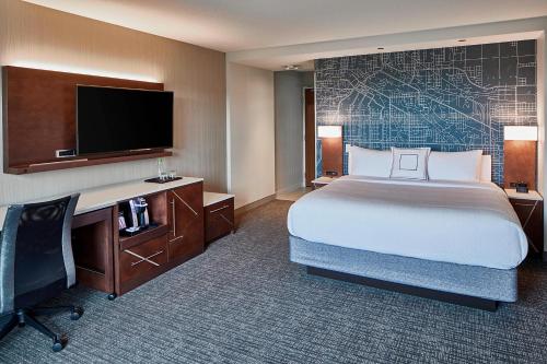 圣路易斯帕克Courtyard by Marriott Minneapolis West的酒店客房配有一张床、一张书桌和一台电视。