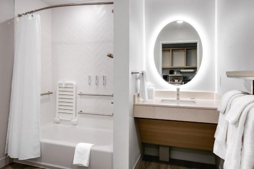 麦迪逊TownePlace Suites by Marriott Madison West, Middleton的带淋浴、盥洗盆和镜子的浴室