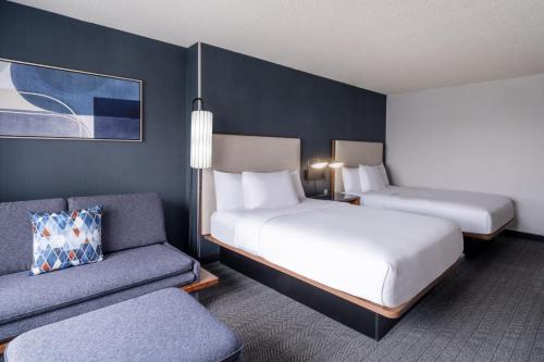 盐湖城盐湖城机场万怡酒店的酒店客房,设有两张床和一张沙发