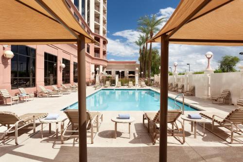 凤凰城Marriott Phoenix Airport的一个带椅子和桌子的酒店游泳池