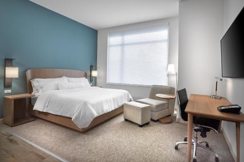 埃德蒙顿Element Edmonton West的一间卧室配有一张床、一张书桌和一台电视