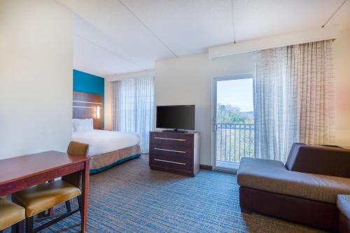 罗利万豪罗利瑰珀翠谷原住酒店的酒店客房配有床、沙发和电视。