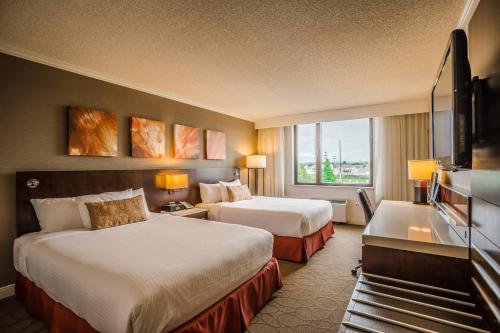 萨格奈沙格奈河三角洲 - 会议中心酒店的酒店客房设有两张床和一台平面电视。