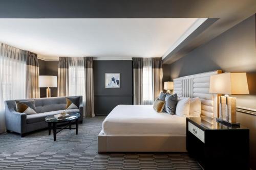 塔尔萨塔尔萨品牌吉臣酒店的酒店客房,配有床和沙发