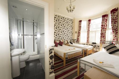 伦敦伦敦皇家萨巴酒店的客房设有带一张床和盥洗盆的浴室