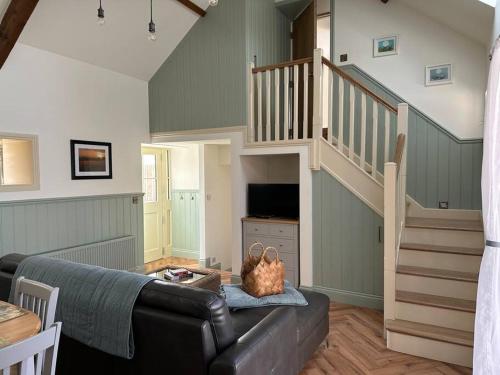 克朗梅尔Murphy's Mountain Cottage的带沙发和楼梯的客厅