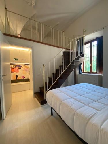 代森扎诺-德尔加达DUOMO26 BOUTIQUE APARTMENT的一间卧室配有一张床和一个楼梯间
