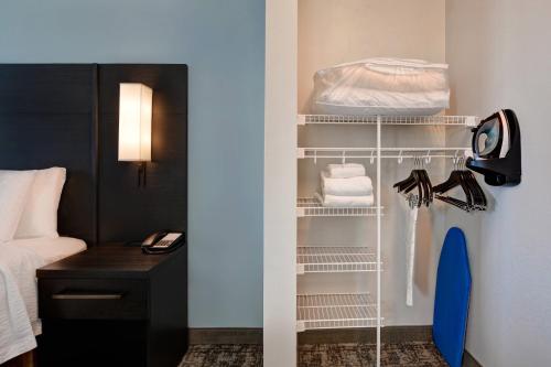 沃尔顿堡滩Residence Inn by Marriott Fort Walton Beach的客房设有一张床和一个带毛巾的衣柜。