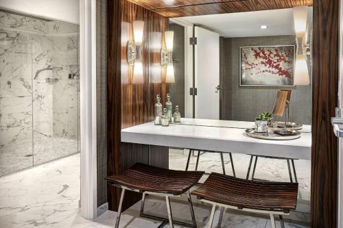 旧金山旧金山尤里安广场JW万豪酒店的浴室设有柜台,镜子前设有两个凳子