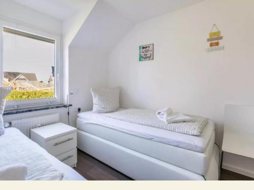 沙博伊茨Meertraum Premium Wohnung mit 3 Zimmern, 250m zum Strand的一间白色卧室,配有两张床和窗户
