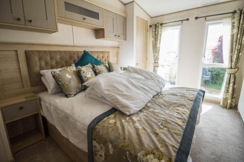 亨斯坦顿Beautiful Lodge At Manor Park In Hunstanton Ref 23018k的一间卧室配有带枕头的床