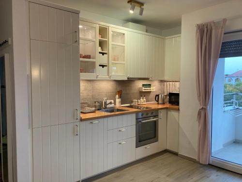 佩罗杰MINT&ROSE的厨房配有白色橱柜和水槽