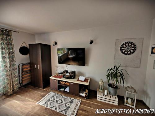 布罗德尼察Agroturystyka Karbowo的客厅的墙上配有电视