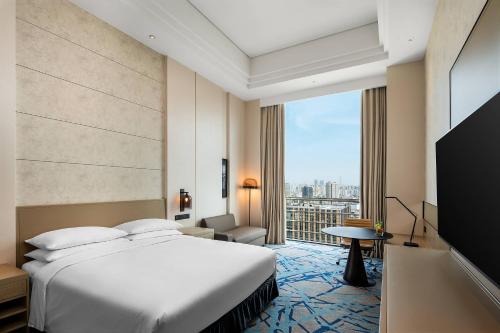 上海上海漕河泾万丽酒店的酒店客房设有一张床和一个大窗户