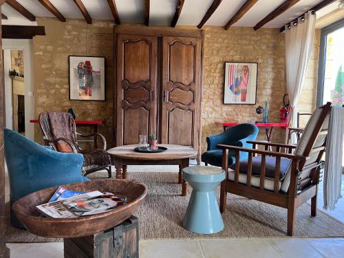 卡尔萨克阿亚克Hôtel La Villa Romaine的客厅配有椅子和桌子