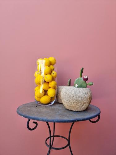 阿尔戈斯托利翁Julietta Suites的一张桌子,上面放着一碗柠檬和一株绿色植物